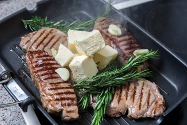 Flütlü tavada kızarmış biftek. Et ve biberiye. Yağ tavada erir..