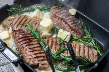 Flütlü tavada kızarmış biftek. Et ve biberiye. Yağ tavada erir..