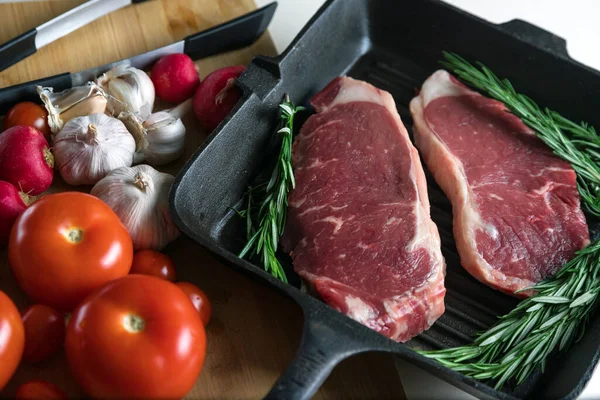 Taze sığır eti. Tavada biftek. Et ve sebze. Mermer biftek. Biberiye ve yağ..