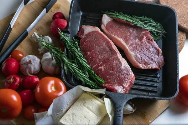 Taze sığır eti. Tavada biftek. Et ve sebze. Mermer biftek. Biberiye ve yağ..