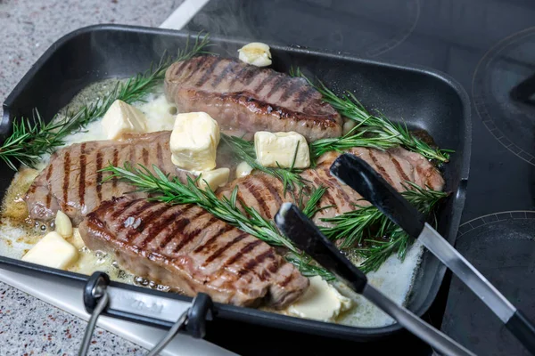 Flütlü tavada kızarmış biftek. Et ve biberiye. Yağ tavada erir..