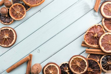 Çerçeve şeklinde ahşap bir masanın üzerindeki kahve çekirdekleri. Tarçın çubukları ve kurutulmuş meyve. Mesaj için yer var. Masada fındık var. turkuaz renk tahtaları.