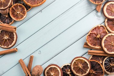 Çerçeve şeklinde ahşap bir masanın üzerindeki kahve çekirdekleri. Tarçın çubukları ve kurutulmuş meyve. Mesaj için yer var. Masada fındık var. turkuaz renk tahtaları.