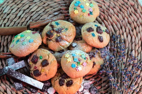 Homemade cookies with chocolate. Still life of cookies on a wicker stand. Cinnamon, chocolate, and a sprig of lavender.