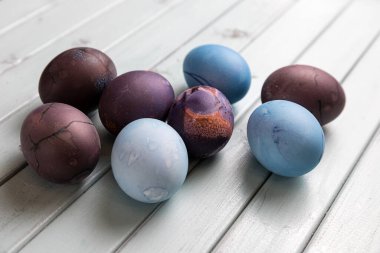 Açık ahşap bir masada renkli Paskalya yumurtaları. Tavuk yumurtaları Paskalya tatili için boyanır..