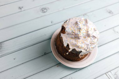 Paskalya pastası. Lezzetli tatlı. Geleneksel tatil pastası. Turkuaz tahtalardan yapılmış bir masada. Şenlikli natürmort.