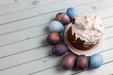 Paskalya pastası ve paskalya yumurtası. Lezzetli tatlı. Geleneksel tatil pastası. Açık mavi bir masada. Paskalya 'da hayat.