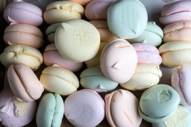 Ahşap bir arka planda renkli tatlı marşmelovları. Hava şekerlemeleri. Şekerleme. Tatlı marshmallow kurabiyelerinin arka planı.