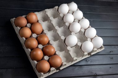 Tavuk yumurtaları, beyaz ve kahverengi. Yumurtalar satranç taşları gibi düzenlenmiş. Yemekle satranç oyunu. Doğal ürün..