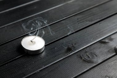 Sönmüş bir mumun dumanı. Tahta bir masada küçük bir mum. Kara tahtalar. Siyah üzerine beyaz.