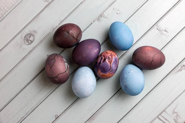 Colored Easter eggs on a light wooden table. Chicken eggs are painted for the Easter holiday.