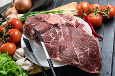 Tahta doğrama tahtasının üzerinde taze seçilmiş sığır eti var. Taze et ve sebzeler sebzeli sulu biftek. Uygun, dengeli beslenme.