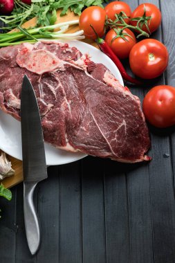 Tahta doğrama tahtasının üzerinde taze seçilmiş sığır eti var. Taze et ve sebzeler sebzeli sulu biftek. Uygun, dengeli beslenme.