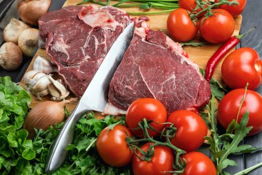 Tahta doğrama tahtasının üzerinde taze seçilmiş sığır eti var. Taze et ve sebzeler sebzeli sulu biftek. Uygun, dengeli beslenme.