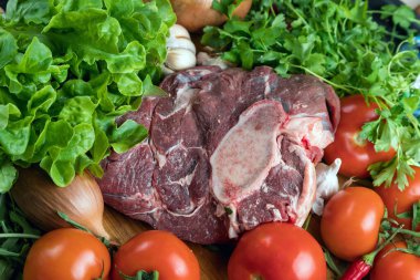 Tahta doğrama tahtasının üzerinde taze seçilmiş sığır eti var. Taze et ve sebzeler sebzeli sulu biftek. Uygun, dengeli beslenme.