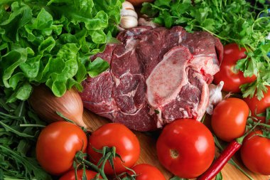 Tahta doğrama tahtasının üzerinde taze seçilmiş sığır eti var. Taze et ve sebzeler sebzeli sulu biftek. Uygun, dengeli beslenme.
