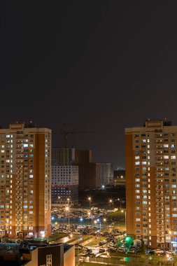 Butovo Park, Moskova 'nın Leninsky bölgesi, Rusya-2020. Sayısız konut binası olan bir bölge. Banliyöler. Banliyöde ışıklar altında bir kasaba. Pencerelerde çok renkli bir ışık var. Şehirde akşam..