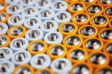 The batteries stand close together and form a beautiful background. Selective focus. Artistic blurring at the edges. Energy source. Patterns. A lot of AA batteries. clipart