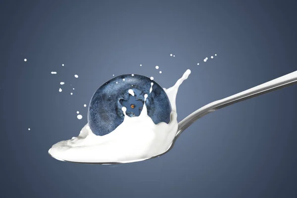 Blueberry jatuh ke susu dengan percikan — Stok Foto