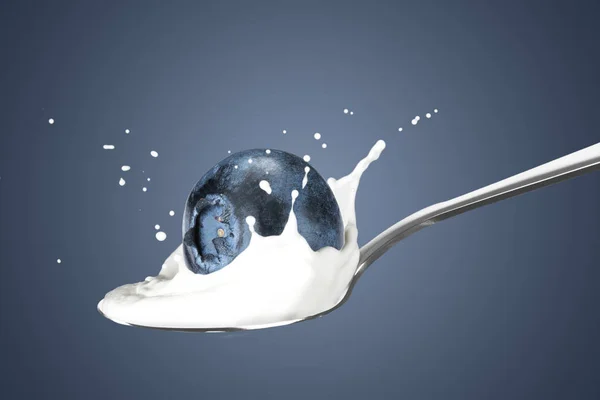 Blueberry falling into milk with splash — Stock Photo, Image