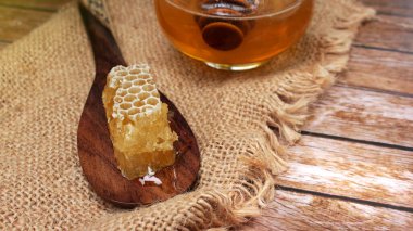 Bal sağlık için besleyicidir, kaşık ve bal peteği ile kavramsaldır.