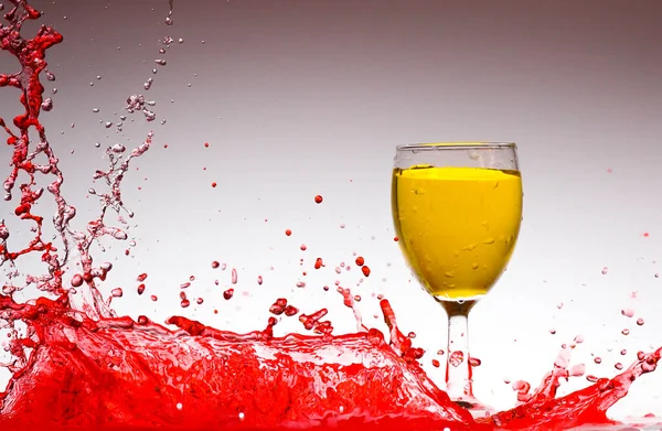 Rozprysk Czerwonej Wody Wewnątrz Pomarańczowej Wody Szkle — Zdjęcie stockowe