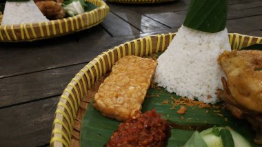 Tumpeng rice namı diğer Nasi Tumpeng, ahşap arka planda erişte ve sebzelerden oluşan otantik ve geleneksel bir Endonezya yemeğidir.