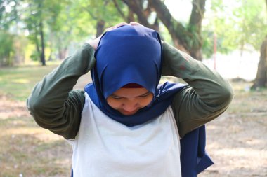 Bir tesettürlü kadın egzersizden önce ısınır.