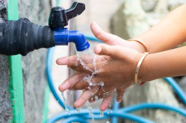 Ellerini akan suda yıkayan küçük çocukların elleri.