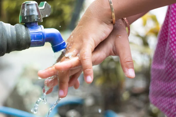 Ellerini akan suda yıkayan küçük çocukların elleri.