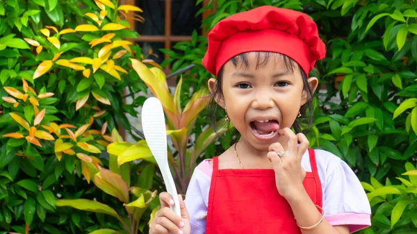 Little girl wearing red cooking clothes