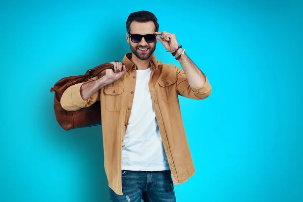 Encantador Joven Sonriendo Ajustando Las Gafas Mientras Está Pie Sobre —  Fotos de Stock