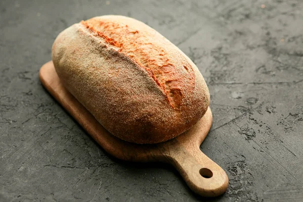 Bread in a basket on a black background. Assorted baking in a metal basket. Place for recipe and text. Background with rolling pin and flour. Rye bread and baguette with seeds. Buckwheat bread