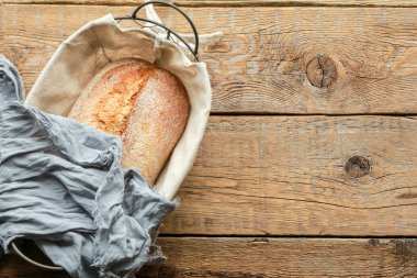 Siyah arka planda sepette ekmek. Metal bir sepetin içinde çeşit çeşit pişirme. Tarif ve metin için yer. Arkaplanda merdane ve un var. Çavdar ekmeği ve ekmekli baget. Karabuğday ekmeği 