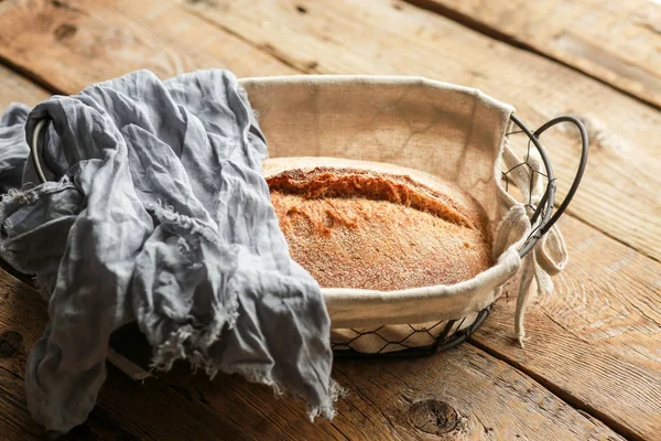 Bread in a basket on a black background. Assorted baking in a metal basket. Place for recipe and text. Background with rolling pin and flour. Rye bread and baguette with seeds. Buckwheat bread