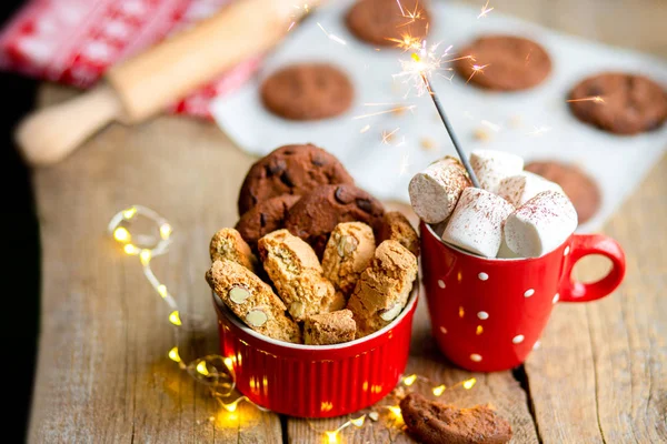 ココアとマシュマロと木製のテーブルの上のクリスマスクッキー クリスマスツリー上のおもちゃでクリスマスキャンディ ホットクリスマスドリンクにチョコレートチップクッキー カップの中のスパークラークリスマス2020 — ストック写真