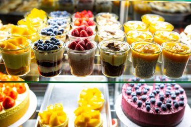 Pencerede çilekli ve çilekli tatlılar var. Bardakta Snickers tatlısı. Dükkanda peynirli kek, hamur işi ve kurabiye satan bir dükkan. Tatil için dolapta şeker var. Pasta.