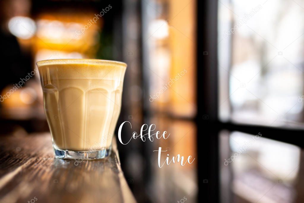 Coffee time. Time for me. Glass with coffee on a wooden table. Cappuccino with almond milk. Vegetarian drink. Relax with a cup of coffee. Latte by the window