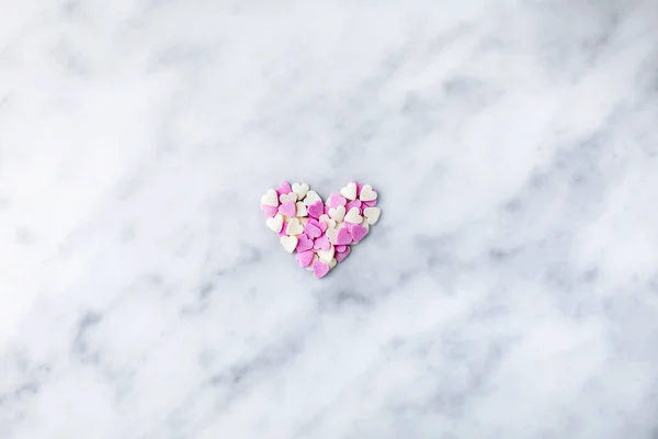 Valentine's Day. Small hearts white and pink are collected in a heart on marble. Valentine's day hearts -place for text.Ball of hearts on a rope.The 14th of February. Romance.Lovers. Tender postcard.