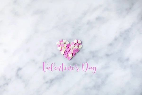 Valentine\'s Day. Small hearts white and pink are collected in a heart on marble. Valentine\'s day hearts -place for text.Ball of hearts on a rope.The 14th of February. Romance.Lovers. Tender postcard.