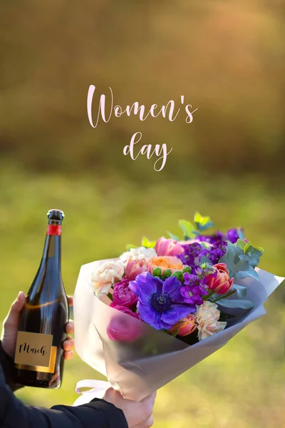 3月8日 男人手中的花朵安排 母亲节 男人拿着一束花和一瓶香槟 母亲节快乐 花作为礼物 文字的位置 母亲节 — 图库照片