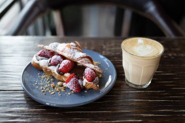 Çilekli kruvasan ve pudra şekerli çikolata. Taze çilekli çıtır kruvasan. Vejetaryen kahvaltısı. Fransız ekmeğiyle kahve. Çilekli çikolatalı kruvasan.