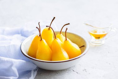 Armut konservesi. Vejetaryen tatlı. Fırına karamelli armut, agave şurubu ve bal dökülüyor. Meyve tatlısı pişiriliyor. Reçelli tatlı, sulu armut. Karamelli meyve.