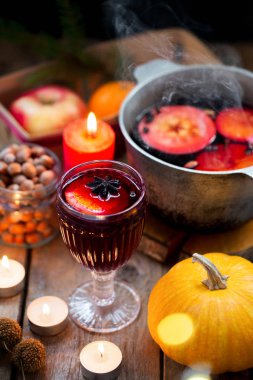 Noel şarabı baharatlı şarap ve ahşap bir kırsal masada meyveler. Geleneksel Noel içkisi. Turunçgil meyvesi, elma ve baharatlı sıcak şarap. Sıcak içecek.