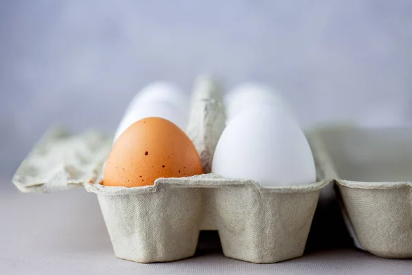 Eggs in a box of different colors. Protein. Healthy foods. Healthy food. Eggs for breakfast. Eggs in the refrigerator on the shelf. Box with eggs on a gray background