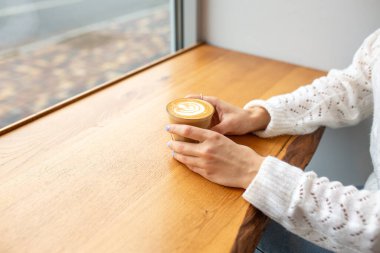 Kremalı bir fincan kahve. Sıcak içecek. Bardakta Latte. Kendine zaman ayır. Romantik bir ortamda nefis bir kahve. Sabah konsepti.