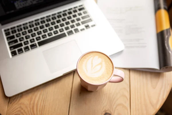 Work at home with a cup of coffee. Home environment with a work process. Time for yourself. Time to drink coffee. Latte with a laptop. Breakfast with work. Read the news during the coronavirus