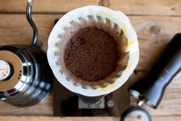 Ground coffee beans in a funnel. Coffee brewing ritual. Making coffee at home.Filtered coffee, or overflow, is a method that involves pouring water onto roasted, ground coffee beans contained in the filter.