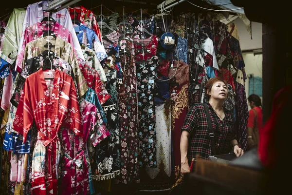 A asian lady buying a chinese robe in Chinatown's street market — Stock Photo, Image