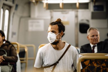 Genç bir virüs metroda koronavirüs enfeksiyonunu önlemek için maske takar.